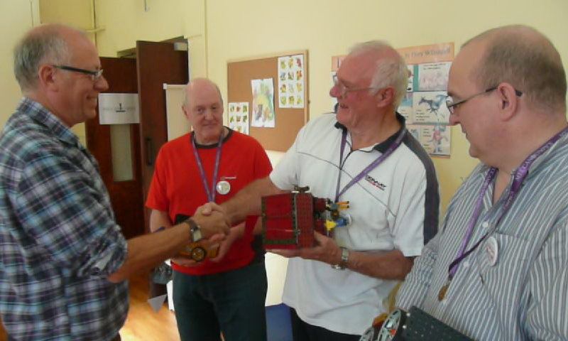 Chris Warrell presents the gold medal to Alan Wenbourne (centre) for the Push-of-War competition at our show on 13th October 2012. Chris Fry (in red) won silver and Ralph Laughton won bronze