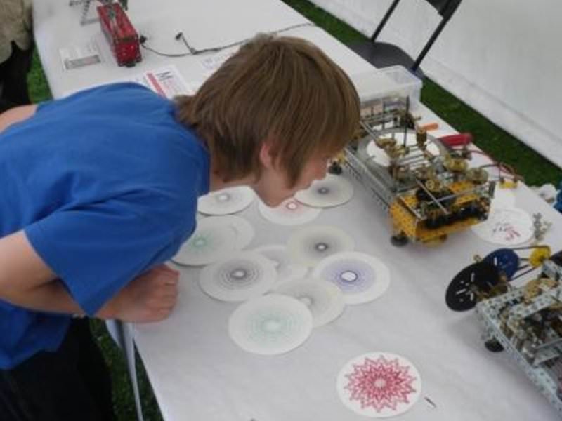 A boy examines the intricate workings of Peter Clay’s Meccanograph
