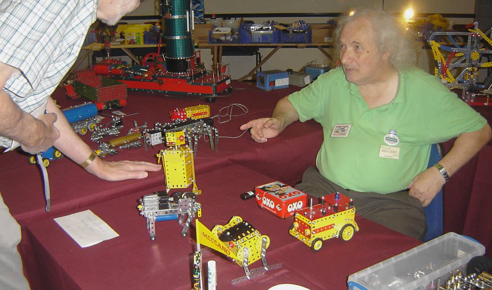 Geoff Carter at the International Meccano Model Show 2008, with a typical collection of small models (Photo: NZMeccano)